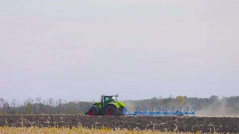 Tractor in the field. A modern tractor plows the field. Green tractor plows the Stock Footage 145127111