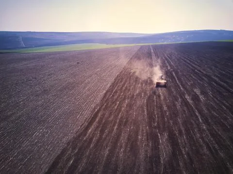 Tractor in a field performing spring sowing., top view from drone pov Stock-Fotos