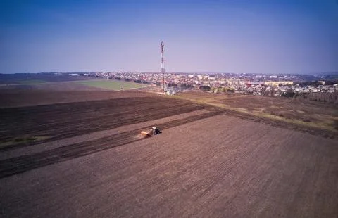 Tractor in a field performing spring sowing., top view from drone pov Stock-Fotos