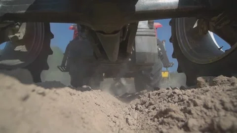 Tractor in the field rides on camera. Fertilizing a field on ploughed land early Stock Footage 221721813