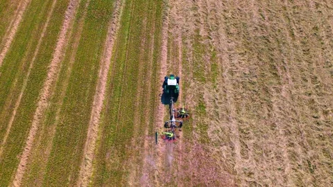 A tractor in the field turning hay Stock Footage 311396287