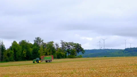 Tractor in the field on wind turbines background. Stock Footage 194415833