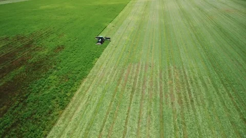 Tractor in field works with high-tech modern mower. Mowing grass with tractor Stock Footage 314060287