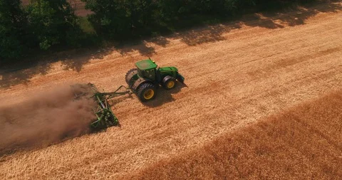 A tractor is going by the gathered wheat field Stock Footage 109307993