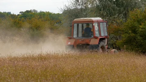 Tractor going through the field and dusting Stock Footage 116997137