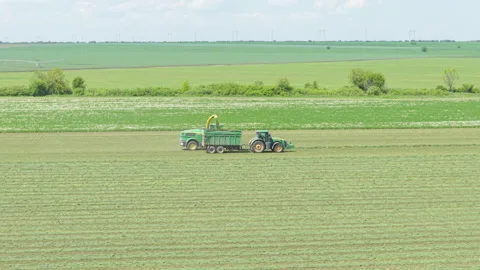 Tractor at Green Wheat Field in Daylight Spring Crop Care in Bulgaria Stock Footage 310367095