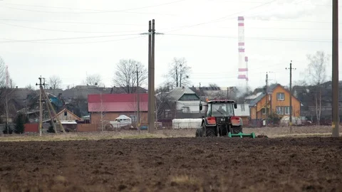 Tractor handles the field with a disk harrow against the background of the Vídeo Stock 129463386