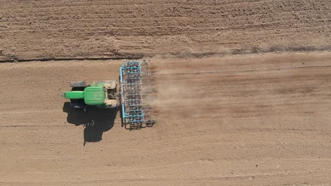 Tractor hard at work ploughing in a field Stock Footage