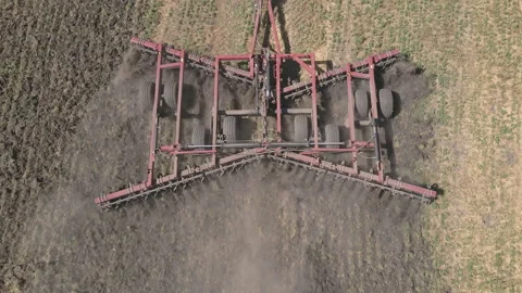 Tractor with harrow system plowing ground on cultivated farm field Stock-Footage 213573223