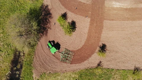 Tractor harrowing the field and storks flying around, searching for food Stock Footage 131589401