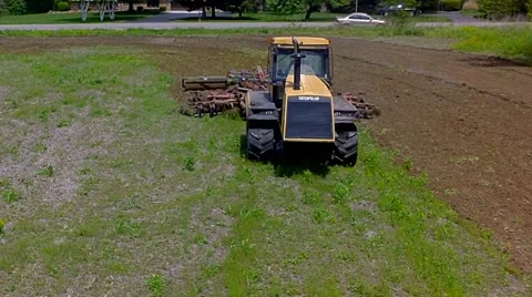 Tractor harrowing the large brown field in spring season Stock Footage 52371017