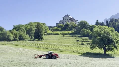 Tractor hay raking below Menthon Castle Vídeo Stock 341293409