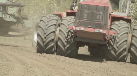 A tractor with a hitched sowing machine, rides on field closeup Stock Footage 64619943