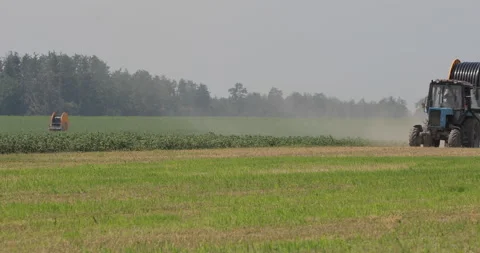 Tractor with Hoses Driving through Corn and Raising Dust Видео 136132341