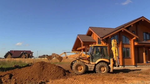Tractor line up land plot with soil near country house Stock Footage 83241557