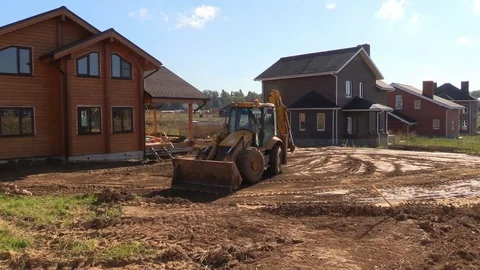 Tractor line up land plot with soil near country house Stock Footage 83241594