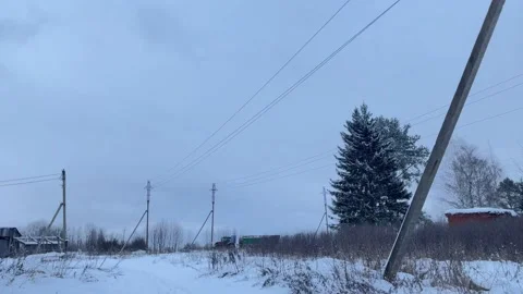 A tractor with a load goes far away in winter, cloudy weather. Stock Footage 169081629