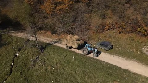 Tractor loaded with hay rides on a mountain road Stock Footage 171290029
