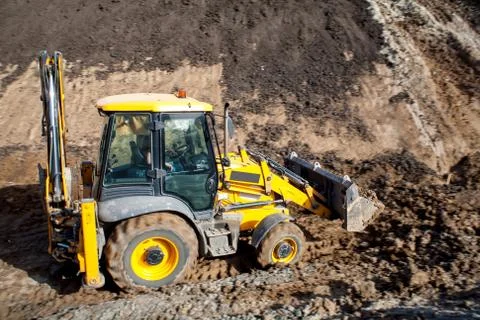 Tractor loader backhoe digger loader on a construction site with blue sky and Stock Photos