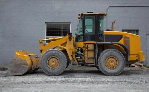 Tractor loader on construction site heavy duty yellow hydraulic equipment Stock Photos