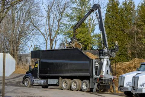 Tractor loading mulch on truck Stock Photos