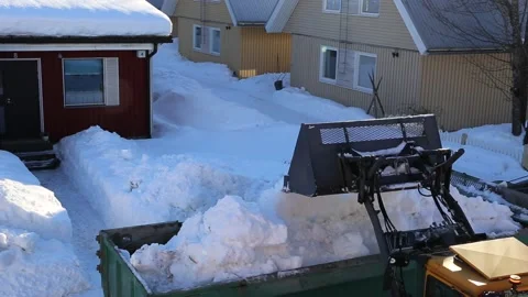 Tractor loading snow in the truck. Spring snow removal Stock Footage 188925731