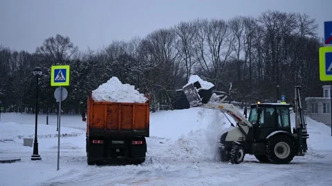 Tractor loading the truck with snow after heavy snow fall in the city Video stock 202305096