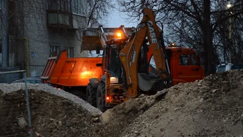 Tractor loads excavated soil into a dump truck Stock Footage 282562987