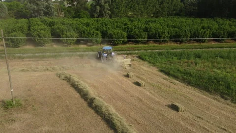 Tractor Machine Working on Hay Bales in Agriculture Field Stock Footage 202319633