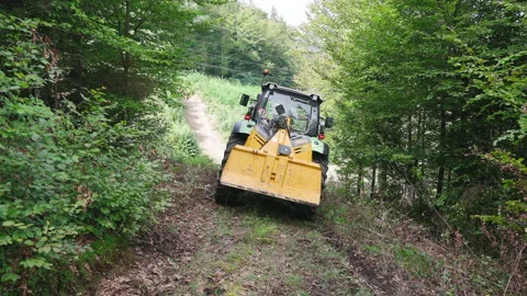 Tractor machinery driving backwards in to forest 4K Stock Footage 161468443