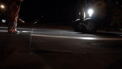 A tractor makes road markings at a pedestrian crossing at night. 스톡 동영상 97523982