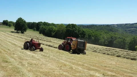A tractor makes a round baller Stock Footage 144484136