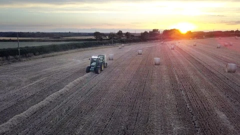 Tractor making hay bales in the evening Stock Footage 92999791