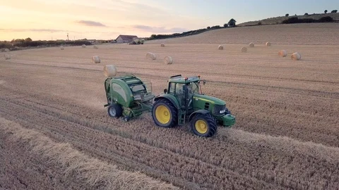 Tractor making hay bales at Sunset Stock Footage 92996710