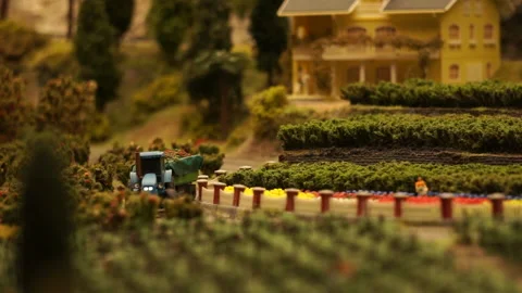 A tractor model with a trailer moves through the countryside. Footage Stock Footage 165123978
