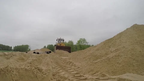 Tractor-mounted loader moving sand and dumping it Stock Footage 158040657