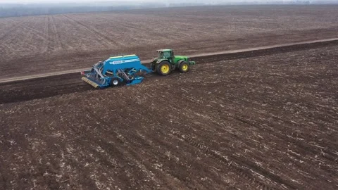 Tractor with mounted seeder performing Stock Footage 153039520