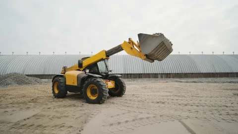 Tractor moves rubble to truck. Excavator-loader rakes rubble from pile  Stock Footage