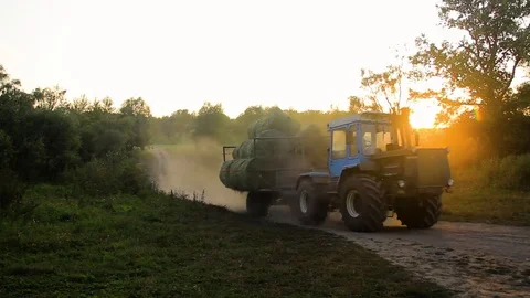 Tractor Moving Bales Of Hay Cut At Sunset Video stock 80477778