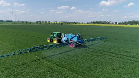 Tractor moving on rape field. Preparing for fertilizing 動画素材 86467038
