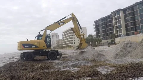 A tractor moving sand on the beach after a hurricane Stock Footage 68678905