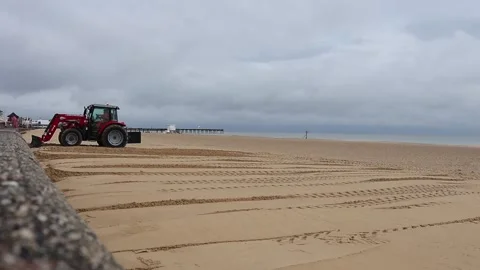 Tractor moving sand on the beach front Video stock 140331184