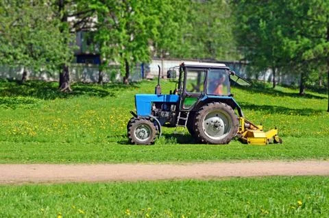 Tractor with mower cutting grass Stock Photos