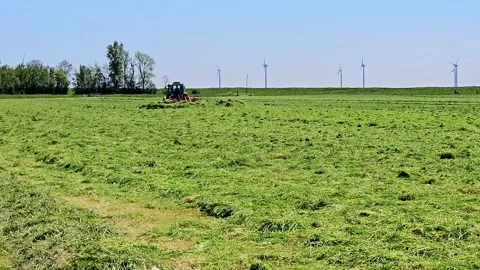 Tractor Mowing or cutting Lush Green Field for Hay Harvest Stock Footage 274905132