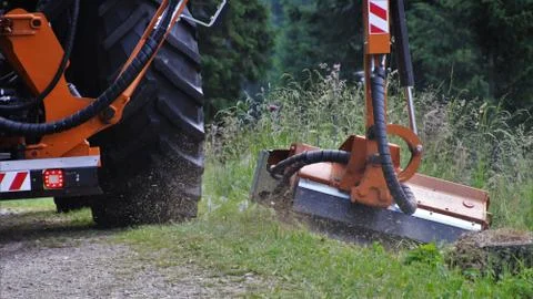 Tractor mows grass along the road. Stock Photos