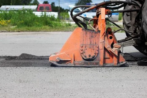 A tractor with a nozzle repairs the road. Patch repair to pits Stock Photos