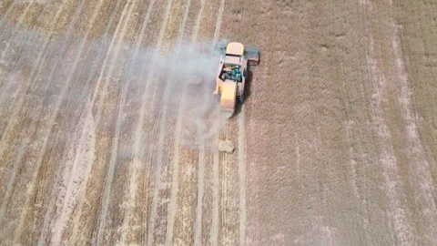 Tractor operates in large field during harvest season in dry weather Stock Footage 302622272