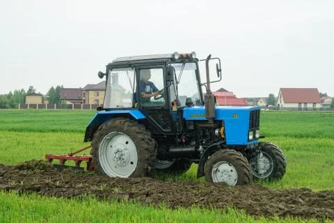 Tractor operator plows the site in rain Stockfoto's