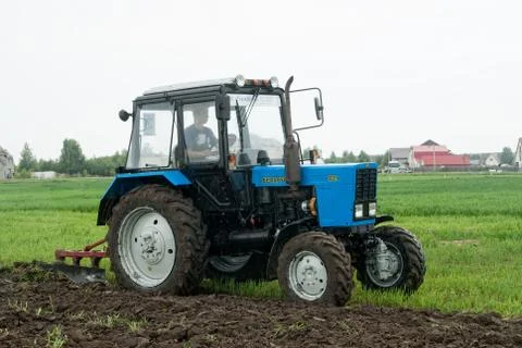Tractor operator plows the site in rain Stockfoto's
