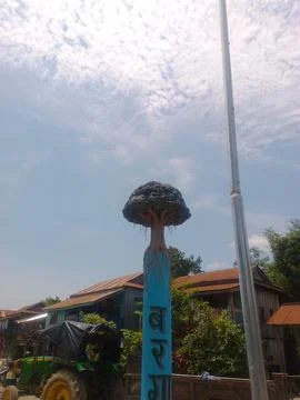 Tractor parked under blue sky with pole. Stock Photos